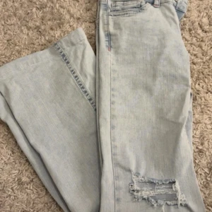 Ljusblå jeans - Super snygga lågmidjade jeans från Nelly med rosa detaljer, storlek 34, och uppsydda så passar någon mellan 160-170 skulle jag säga💕 använda några få gånger!  Nypris 699