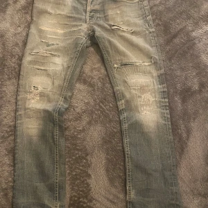 Nudie jeans  - Tja säljer ett par tvär feta jeans från Nudie i storleken 32/32 och är i bra skick. Det är en grå blå färg som gör jeansen så snygga med sköna slitningar. Priset går att diskuteras 