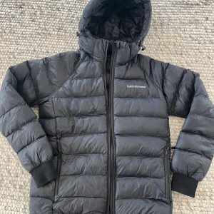 Peak performance jacka  - Peak performance svart vinterjacka i stl 160.  Modell: JR Tomic Insulated Hood Jacka         Nypris idag: ca 2000kr Webbsida: https://kidsbrandstore.se/products/jr-tomic-insulated-hood-831934?utm_source=google&utm_medium=cpc&utm_campaign=p-se-performance.max&gad_source=1&gad_campaignid=23023884719&gbraid=0AAAAADvzalKEBBLbQzJiu7ebCY483Scbd&gclid=EAIaIQobChMI2IXY0KWjkAMVmBmiAx2SMDtlEAQYBCABEgIEQvD_BwE Använd två säsonger. Väl omhändertagen med ytterst små och få defekter. Be om fler bilder. 