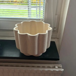 Jotex Vas - En vågig beige kruka eller vas..