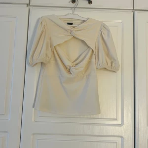 Beige blus med knyt från Gina Tricot💕✨ - Supersnygg beige blus från Gina Tricot i storlek S. Blusen har puffiga korta ärmar, cool knytning fram även så snygg cutout!💖 . Materialet känns mjukt och lätt, perfekt för att sticka ut med en unik look. Passformen är normal och toppen är croppad.