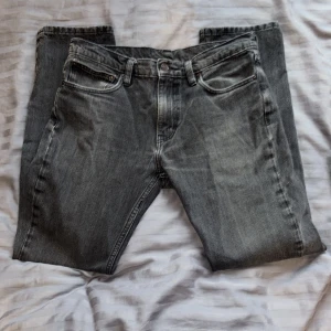 Grå Levis 511 jeans straight fit - Säljer ett par klassiska Levis 511 jeans i snygg grå tvätt. Modellen har rak passform, fem fickor och knappgylf. Perfekt för dig som gillar tidlös stil och vill ha ett par jeans som funkar till allt. Storlek enligt bild, fråga gärna om mått!