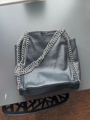 Jätte söt svart väska  - En jätte fin väska med kjedie band köpte för 600kr tror jag så den ligger runt 250kr för att den har gått upp i öppningen men annars är den i jätte fint skick 