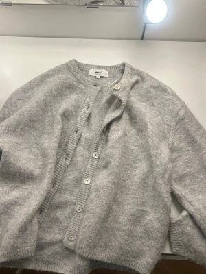 Grå stickad Kofta - Säljer denna jätte fina gråa koftan, eftersom den inte kommer till användning. Den är i jätte bra skick och har nästan aldrig används. Skriv om ni har frågor eller vill ha fler bilder💕💕