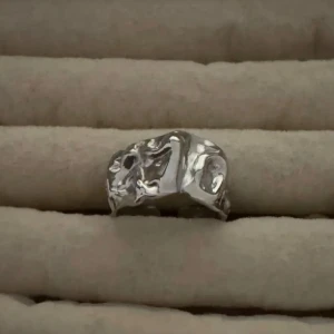 Extra ring på köpet ❣️ - Säljer två unika silvriga ringar i modern design. Den ena har en organisk, skulpterad form med rå yta, medan den andra har en stilren, böljande form som slingrar sig runt fingret. Båda är i blankt metallmaterial och passar perfekt för dig som gillar trendiga accessoarer.