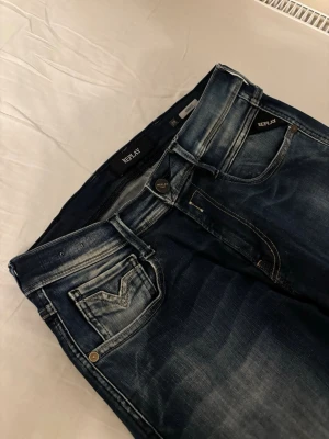  Replay Anbass - Snygga mörkblå jeans från Replay med coola slitningar. Klassisk femficksmodell med detaljerade bakfickor och logga på linningen. Perfekta för dig som gillar en avslappnad men trendig stil. Storlek w29 l32 tveka inte för att höra av dig om frågor! Jeansen är i väldigt bra skick!