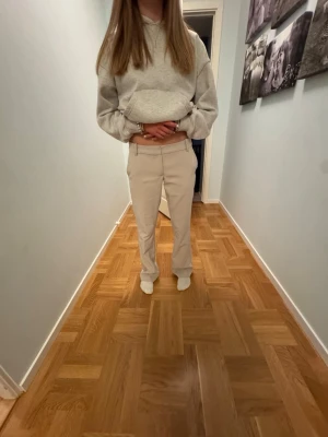 Beiga kostymbyxor från BikBok - Säljer ett par beiga kostymbyxor från BikBok. Det är inget fel på dom utan dom sitter bara lite stort i rumpa och lår. Kostymbyxorna har låg midja och klassisk femficksdesign. Materialet är mjukt för extra komfort. Perfekta till en avslappnad och stilren look.