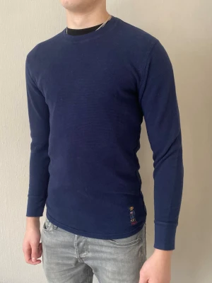 Mörkblå tröja Polo Bear Ralph Lauren - Mörkblå tröja från Polo Ralph Lauren. Nedtill finns den broderade polo bear loggan. Tröjan har en enkel, stilren design och är perfekt för varje dag! fraktar oftast samma dag eller inom 24h📦 köp mer än ett plagg för 10% rabatt!🤝