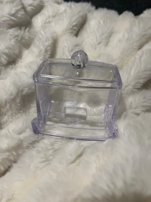 Transparent förvaringsbox med lock - Snygg och stilren transparent förvaringsbox i plast med lock och rund knopp. Perfekt för att förvara bomullspads, tops eller små skönhetsprylar på sminkbordet. Rektangulär form och enkel att öppna och stänga.