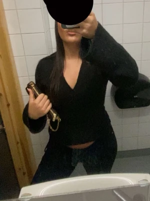 Svart omlottkofta från Gina Tricot - Trendig svart omlottkofta från Gina Tricot med långa ärmar och knytband i midjan. Koftan har en djup v-ringning och är gjord i ett mjukt, stickat material som passar perfekt till jeans eller kjol.