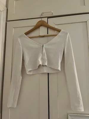 Vit kofta  - Vit kofta som har en dragkedja och är lite cropped