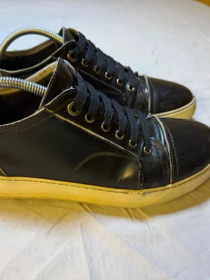 Lanvin Cap sneakers svarta – Läder – Strl 43 – Mycket fint skick -  Säljer ett par Lanvin Cap Tor sneakers i svart läder, storlek 43, i mycket fint skick. Extremt snygg och clean modell som ger en exklusiv look utan att vara för flashy.  Lanvin Cap är en ikonisk designer-sneaker som passar perfekt till både streetwear och mer uppklädda outfits.  • Märke: Lanvin • Modell: Cap • Material: Läder • Storlek: 43