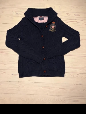 Kabelstickad kofta Ralph Lauren  - Stickad cardigan från Ralph lauren i väldigt bra skick. Sparsamt använd och är verkligen mycket kvar att använda. Inget alls att anmärka på angående skicket.  Storlek S/M Hör gärna av er vid frågor!