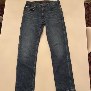 Tommy Hilfiger blå jeans 30/32 - Snygga blå jeans från Tommy Hilfiger med klassisk femficksdesign och diskret logga på bakfickan. Jeansen har raka ben och normal passform, tillverkade i slitstarkt bomullsjeans. Perfekta för dig som gillar stilrena och tidlösa plagg.