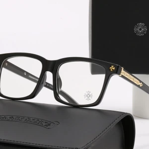 Svarta glasögon från Chrome Hearts - Snygga svarta glasögon från Chrome Hearts med rektangulär form och coola guldfärgade detaljer på skalmarna. Glasögonen har en stilren design med logotyp och blomdetalj på linsen. Perfekt för dig som vill ha en unik och trendig look. ( låda tillkommer inte )