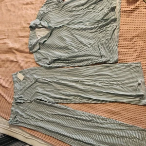 Randiga pyjamaskläder från Nordstrom XL - Grön- och vitrandiga pyjamaskläder från Nordstrom i storlek XL. Byxorna har elastisk midja med snörning och är tillverkade i mjukt, tunt material. Perfekta för chill dagar hemma. Klassisk rak passform och snygg randig design.