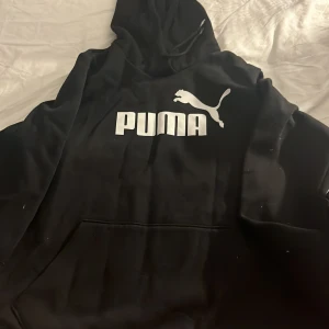 Svart hoodie från Puma med logga - Svart hoodie från Puma. Klassisk känguruficka framtill, huva med snörning och mjukt material på insidan. Hör av er vid frågor/intresse💕