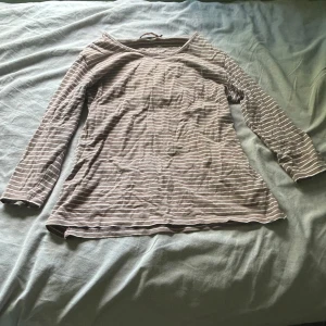 Randig tröja  - Säljer en brun tröja från Time med tunna vita ränder. Den är i storlek L och har lite trekvartslånga ärmar