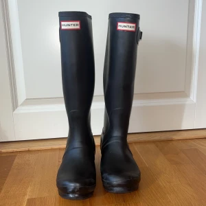 Svarta Hunter stövlar EU 38/ UK 5 - Säljer ett par klassiska svarta Hunter stövlar i storlek EU 38/ UK 5. De är höga med justerbart spänne på sidan med Hunter-logga framtill. 