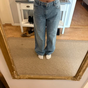 Wide jeans från Pull&Bear ljusblå - Säljer ett par ljusblå jeans från Pull&Bear i storlek 38. Modellen är wide fit med hög midja och raka, vida ben. Klassisk femficksdesign och knappgylf. Perfekta för en avslappnad och trendig look. Stor i storlek. 