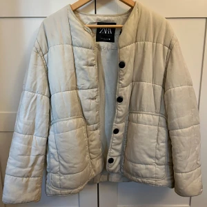 Beige quiltad jacka från Zara - Quiltad beige jacka från Zara med rund halsringning och stora svarta knappar framtill, super fin och passar verkligen varje outfit! Perfekt höstjacka!!!!