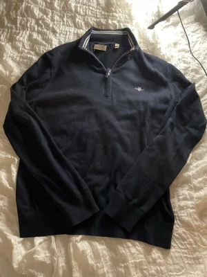 Marinblå half zip tröja från Gant - En marinblå half zip tröja från Gant i storlek 158/164. Tröjan är i bra skick utan några synliga skador och har använts varsamt. Vid fler frågor eller funderingar är det bara att kontakta mig!