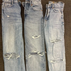 Tre par ljusblå slitna  jeans - Tre par ljusblå  jeans med snygga slitningar och hål vid knäna. Klassisk femficksmodell med raka ben och hög midja. Perfekta för en avslappnad stil. 90kr styck. Från märkena Zara och Gina. De från gina (längst till höger) är i stl 32🙌🏻🩷🌸