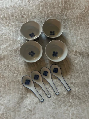 Skålar med skedar  - Bilderna visar fyra vita skålar med blått blommönster och fyra  matchande skedar.