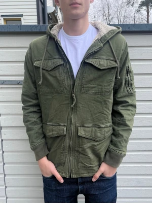 Hollister jacka med foder - Tja säljer nu denna sjukt snygga vintage jacka från Hollister med foder. Skick 8.5/10 riktigt bra med små tecken på användning som knappt syns. Modell: 184cm och väger 72kg, passar allt mellan 178-188 som bäst. Hör av er vid funderingar!
