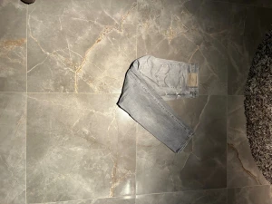 Grå Jack & Jones jeans superstretch slim fit - Säljer ett par grå Jack & Jones jeans slim fit  Klassisk femficksmodell med dragkedja fram. Jeansen har en ljusgrå tvätt och är tillverkade i mjukt jeanstyg med superstretch för extra komfort. Perfekt för dig som gillar en smal siluett.