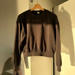 H&M svart sweatshirt - Säljer en svart sweatshirt från H&M i mycket fint skick.
 Modellen verkar vara från ett samarbetssläpp med Blackpink och har en minimalistisk hjärtdetalj på bröstet som ger ett subtilt men unikt uttryck.
 Tyget är mjukt, bekvämt och håller formen väl. Passformen är avslappnad men ändå snyggt skuren, perfekt för både vardag och fritid.
 Material: 61 % bomull, 39 % polyester
 Storlek: S (165/88A)
 Finns för upphämtning i Kista, Stockholm, eller skickas mot frakt.

