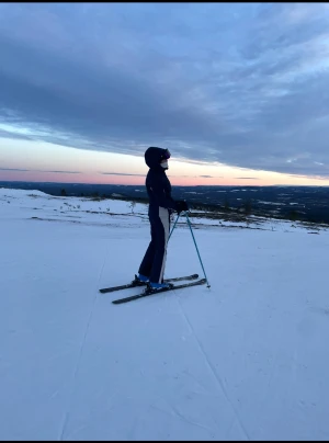 Mörkblå skidkläder - Säljer ett par mörkblå skidkläder med vitt längs sidorna. Byxorna har en rak passform och är perfekta för skidåkning eller andra vinteraktiviteter. Materialet är tåligt mot snö och vatten och håller dig varm i backen. Snygg och sportig look för dig som gillar att vara ute på vintern.