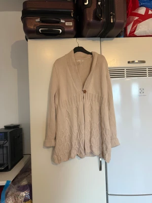 Beige stickad kofta Odd Molly - Säljer en beige stickad kofta från Odd Molly med snyggt mönster nedtill och ribbade muddar. Koftan har v-ringad hals, en knapp framtill och långärmade ärmar. Perfekt för dig som gillar chill och mysig stil. Från märket Odd Molly. Storlek 3 som enligt deras storleksguide motsvarar en L. Mycket fint skick, jag hittar inga synliga anmärkningar eller defekter. 