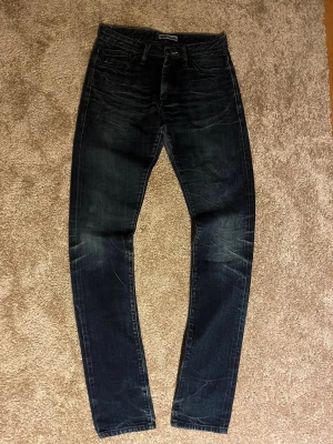 Mörk blå Acne jeans - Säljer dessa otroligt snygga jeansen från acne jeans. Dem har riktigt feta slitningar som ni ser på bilden. Inga defekter alls och är i väldigt bra skick! Kostar nya flera tusen!👌w26 och L 34