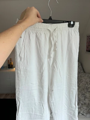 Vita linnebyxor från Lager157, storlek S - Säljer ett par vita linnebyxor från Lager157. Byxorna har fickor på sidorna och en bakficka. Perfekta för en bekväm och stilren look. Använda 2-3 gånger. 