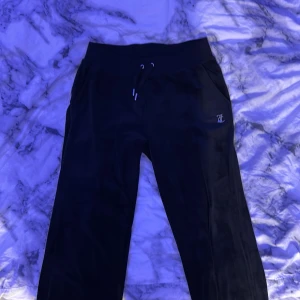 Svarta Juicy Couture mjukisbyxor S - Svarta mjukisbyxor från Juicy Couture i sammet med glittrande strasstenar. Klassisk Juicy-logga i stenar på baksidan och JC-detalj framtill. Byxorna har snörning i midjan och en skön, loose passform. Aldrig använda 💕 
