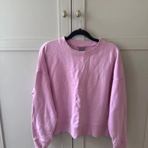 Ljusrosa sweatshirt med loose fit - En ljusrosa sweatshirt från Gina Tricot med loose fit och ribbade muddar vid ärmslut och hals. Tröjan har rund halsringning och långa ärmar, perfekt för chill dagar. Materialet är mjuk bomull som känns skönt mot huden.