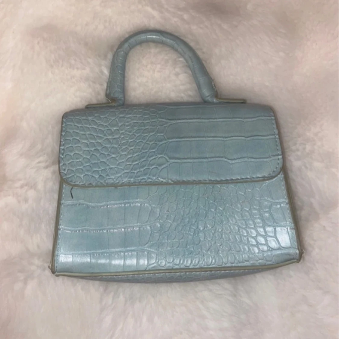 Ljusblå handväska med krokoprägling