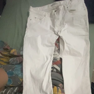 Vita jeans från J.Lindeberg Denim - Snygga vita jeans från J.Lindeberg Denim med klassisk femficksdesign och metallogo på myntfickan. Jeansen har rak passform och är tillverkade i mjukt bomullsmaterial. Perfekta för dig som gillar stilrena och fräscha looks.