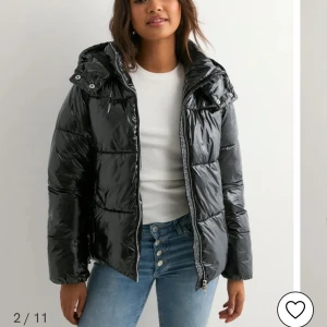 Svart pufferjacka - Säljer en svart, glansig pufferjacka med huva och dragkedja.🥰 