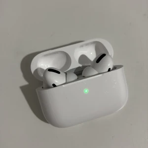 AirPods Pro - Snygga Apple AirPods Pro med laddningsetui. Trådlösa hörlurar med aktiv brusreducering och bekväm passform. Fungerar utmärkt, med endast mindre ytliga repor på etuiet. Perfekt för musik, samtal och träning. Levereras komplett med originalfodral.