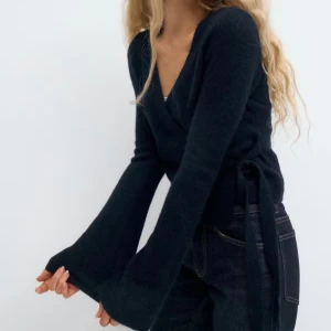 Mörkblå omlottkofta från Gina Tricot - Snygg mörkblå omlottkofta från Gina Tricot i mjuk ullblandning. Koftan har långa ärmar med lätt utsvängd form, v-ringad hals och knyt i sidan för en schysst passform. Perfekt att slänga på sig när det är lite kyligt ute. Inte prislapp kvar men använd endast ett fåtal gånger💙