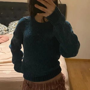 Mörkgrön tröja  - Säljer en mysig mörkgrön stickad tröja med ribbad struktur. Tröjan har rund halsringning och långa ärmar med breda muddar. 