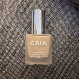CAIA It's Iconic Foundation 1W - Flytande foundation från CAIA i nyansen 1W, med hyaluronsyra och vitamin C samt SPF 20. Kommer i en stilren, frostad glasflaska med silvrig pump. Ger en silkeslen finish och är tillverkad i Italien. Innehåller 30 ml.