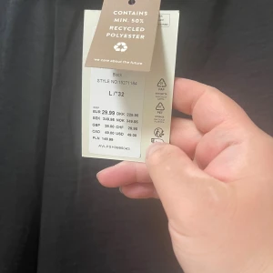 Svarta vida byxor från JDY - Svarta byxor från JDY i storlek L/32 med bred resår i midjan och rak, vid passform. Tillverkade av minst 50% återvunnen polyester, vilket gör dem både snygga och miljövänliga. Perfekta för en chill och stilren look.