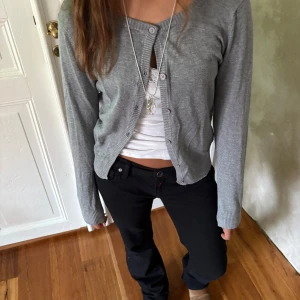 Grå kofta - Säljer en grå kofta med en unik detalj vid armbågarna som ger plagget en extra stilfull och personlig touch. Mjuk och bekväm, perfekt för både vardag och lite finare tillfällen.