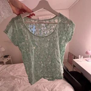 Mintgrön spetsblus med blommönster - Säljer en mintgrön blus från Gina Tricot med blommigt spetsmönster. Blusen är kortärmad och har en rund halsringning. Aldrig använd!🩵