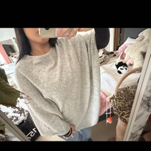 Grå oversized poncho SoyaConcept - Supermjuk och oversized grå stickad poncho  från SoyaConcept. Ponchon har en lös passform, rund halsringning och diskreta glittriga trådar i materialet. Perfekt för lager-på-lager och chill vibes.