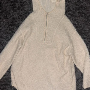 Hoodie/kofta - Mysig beige hoodie från H&M i storlek M. Tröjan är gjord i mjuk fleece med huva och half zip-dragkedja framtill. Perfekt för kalla dagar och har långärmad passform. Enkel och stilren design som är lätt att matcha med andra plagg.