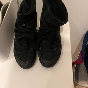 Svarta Inuikii -  Jättefina in Nukes med lite skador här och där på grund av att de är välanvänd men jättefina jättevarma inför vintern och har även en klack som går att ta bort Men den syns inte utifrån det finns lite skador här och där fråga om bilder om ni vill ha